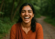 Person wearing an orange shirt standing outdoors with a blurred natural background