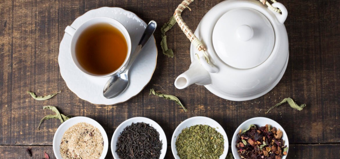 herbal-tea-cup-teapot-with-bowls-tea-herbs-wooden-desk